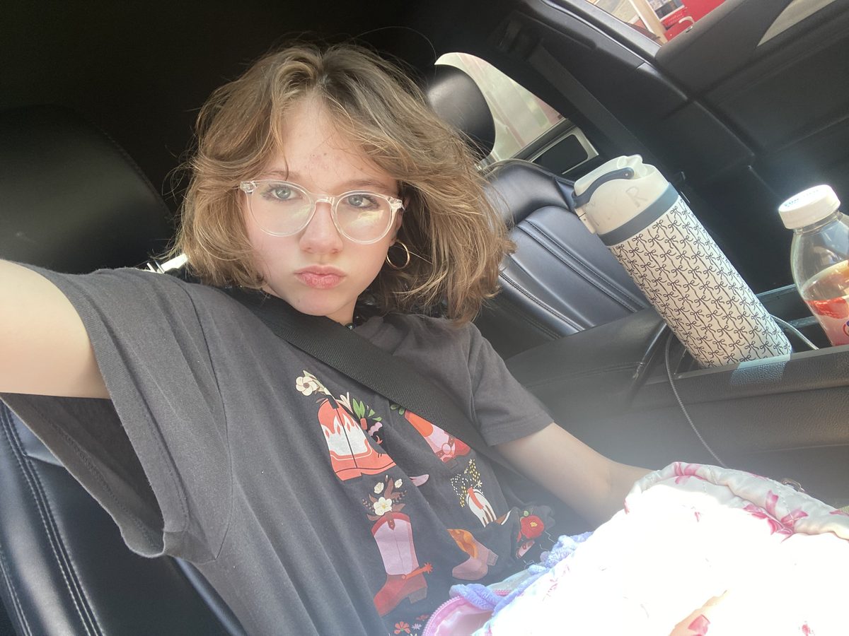 Lily smiling in the passenger seat of a car